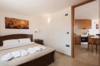 a bedroom with a bed with towels on it at Mythos Beach Hotel Apartments in Maleme