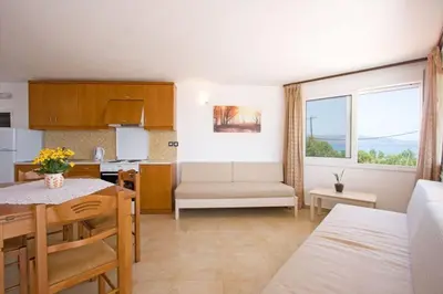 a living room with a kitchen and a dining room at Mythos Beach Hotel Apartments in Maleme