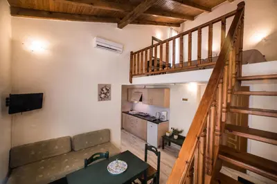 a small living room with a couch and a staircase at Mythos Beach Hotel Apartments in Maleme