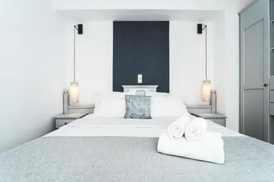 a bedroom with a large white bed with towels on it at Zeus Village Resort - Adults Only in Kato Daratso