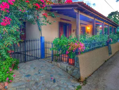a house with potted plants on a balcony at Elisavet's House in Plataniás