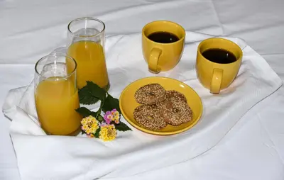 a table with a plate of donuts and two glasses of orange juice at Elisavet's House in Plataniás