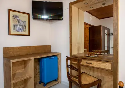 a room with a desk with a blue suitcase and a chair at Elisavet's House in Plataniás