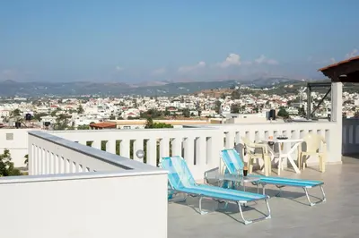 a balcony with chairs and a table and a view at Joanna 's Loft in Kissamos