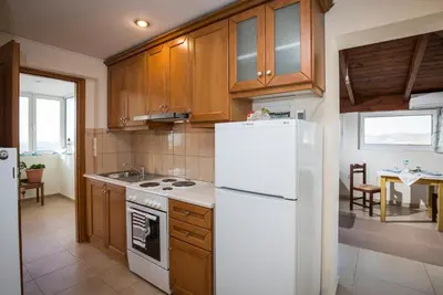 a kitchen with wooden cabinets and a white refrigerator at Joanna 's Loft in Kissamos