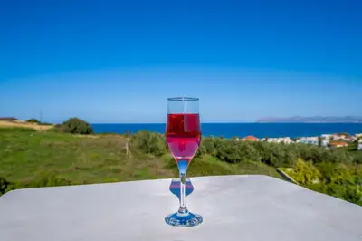a glass of wine sitting on top of a table at Casa Leone Suites in Stalos