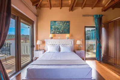 a bedroom with a large bed and a balcony at Casa Leone Suites in Stalos