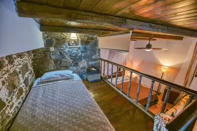 a bed in a room with a stone wall at 