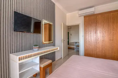 a bedroom with a bed and a tv on a wall at Christina Beach Hotel in Kissamos