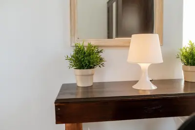 a lamp on a table with two potted plants at Pixelart Home in Kounoupidhianá