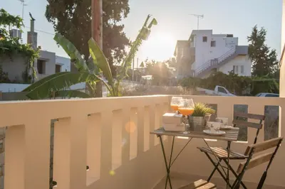 a table on a balcony with two glasses of wine at Pixelart Home in Kounoupidhianá
