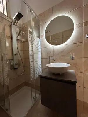 a bathroom with a sink and a shower with a mirror at Sofias Home in Chania Town