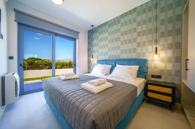 a bedroom with a bed with two towels on it at Naval villa-Panoramic villa with heated pool on the roof in Gerani Chanion