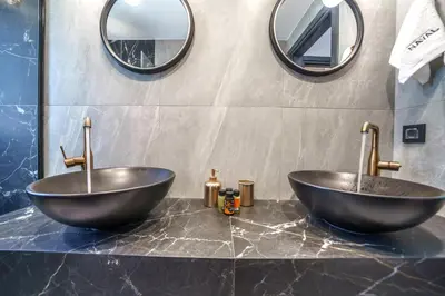 two sinks in a bathroom with two mirrors at Naval villa-Panoramic villa with heated pool on the roof in Gerani Chanion