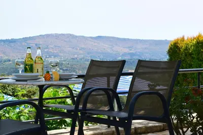 a table with two bottles of wine and two chairs at Aspalathos Villas in Fílippos