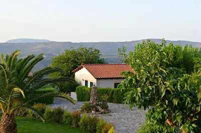 a house in the middle of a garden with trees at Aspalathos Villas in Fílippos