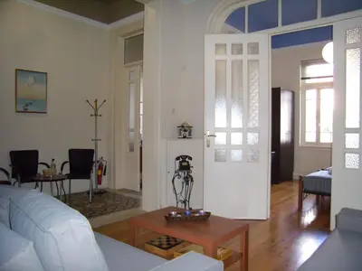 a living room with a white couch and a table at Neoclassical Glamour in Chania Town