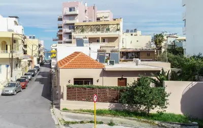 a small white house with a red roof on a city street at Iro City and Beach Boutique Homes in Chania Town