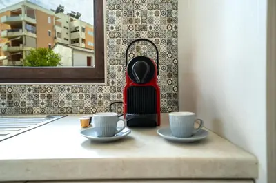 a table with two cups of coffee and a red juicer at Iro City and Beach Boutique Homes in Chania Town