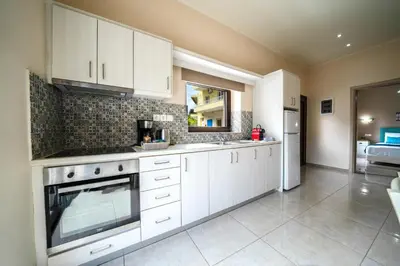 a kitchen with white cabinets and a stove at Iro City and Beach Boutique Homes in Chania Town