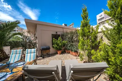 a patio with chairs and a grill in a backyard at Iro City and Beach Boutique Homes in Chania Town