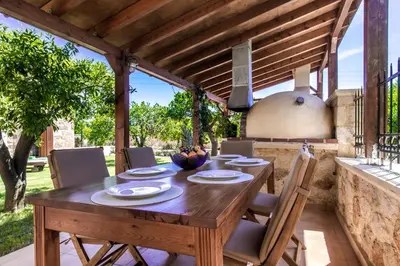 an outdoor dining room with a wooden table and chairs at Villa Anerocurù by Chania city in Chania Town