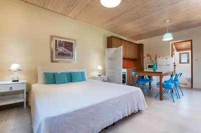 a bedroom with a bed and a kitchen with a table at Villa Anerocurù by Chania city in Chania Town