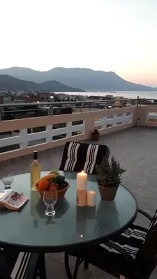 a table with a bowl of fruit and candles on a roof at Kissamos View Apartment in Kissamos
