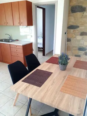 a kitchen with a wooden table with chairs and a counter at Kissamos View Apartment in Kissamos