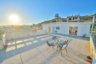 a patio with a table and chairs on a balcony at Kissamos View Apartment in Kissamos