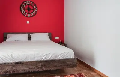 a red bedroom with a bed with a clock on the wall at Veranda Apartment in Chania Town