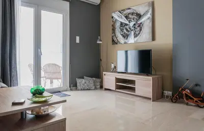 a living room with a flat screen tv on a wooden entertainment center at Veranda Apartment in Chania Town