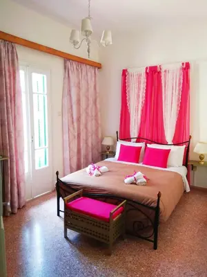a bedroom with a large bed with pink curtains at The Manor House in the Old Town in Chania Town