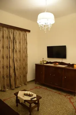 a living room with a television and a table at The Manor House in the Old Town in Chania Town