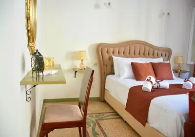 a bedroom with two beds and a chair and a desk at The Manor House in the Old Town in Chania Town
