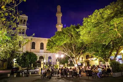 a group of people sitting at tables in front of a mosque at Casa Minaretto in Chania Town