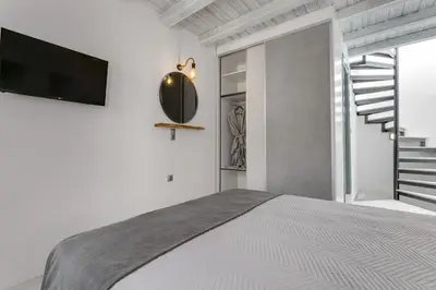 a bedroom with a bed and a tv on a wall at Casa Minaretto in Chania Town