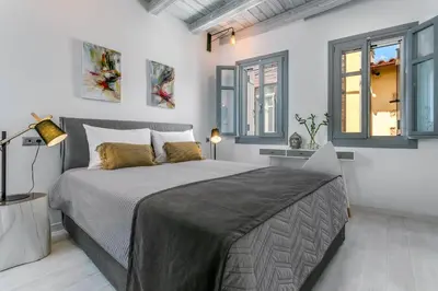 a bedroom with a bed and two windows at Casa Minaretto in Chania Town