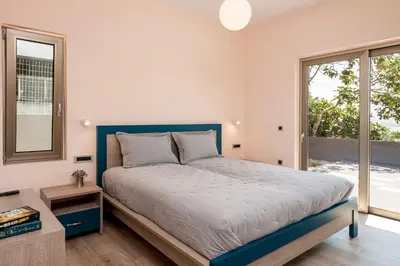 a bedroom with a large bed and a window at Blue Sea Chania Villa in Chania Town