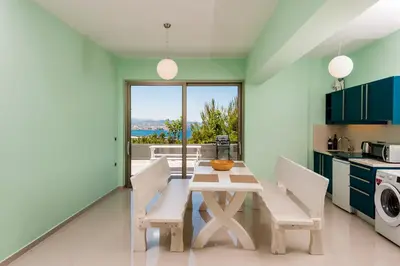 a kitchen with a table and chairs with a view at Blue Sea Chania Villa in Chania Town