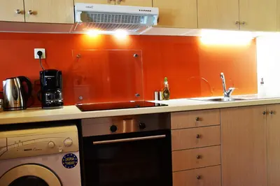 a kitchen with orange walls and a sink and a dishwasher at Minaret's View ζήστε στην αύρα της παλιάς πόλης in Chania Town