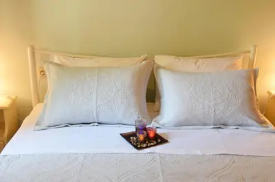 a tray of candles on a bed with two pillows at Minaret's View ζήστε στην αύρα της παλιάς πόλης in Chania Town
