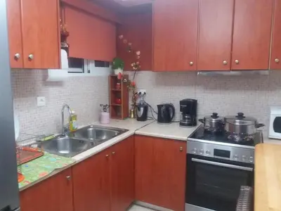 a kitchen with wooden cabinets and a sink and a stove at Kostaspant apartment in Gerani Chanion