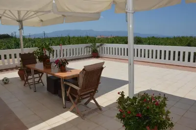 a table and chairs under an umbrella on a patio at Kostaspant apartment in Gerani Chanion