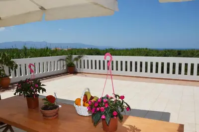a table with fruits and flowers on a patio at Kostaspant apartment in Gerani Chanion