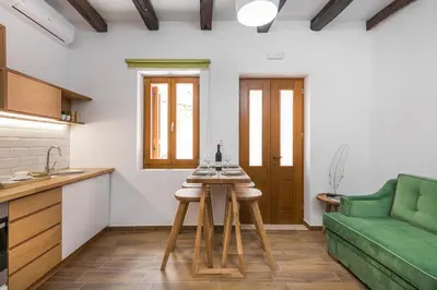 a kitchen and living room with a green couch at Evlimeni Suites in Chania Town
