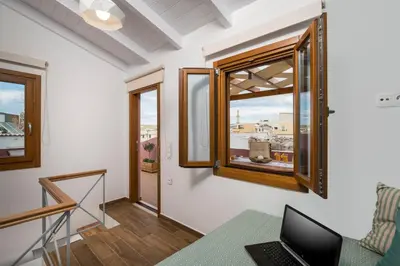 a room with a laptop on a table and a window at Evlimeni Suites in Chania Town