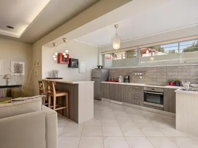 an open kitchen with a bar and a dining area at Villa Athinais in Gerani Chanion