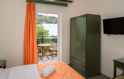 a bedroom with a green cabinet and a balcony at Aretousa in Sougia