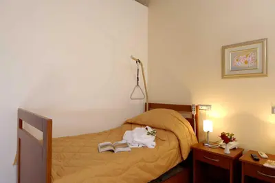 a bedroom with a bed with two books on it at ERIA RESORT for people with special abilities in Maleme